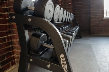 Astrakhan, Russia, 09 of April 2018; Dumbbells of Technogym brand in row in local sport club. Technogym is one of liders in gym equipment market in the world.のeditorial素材