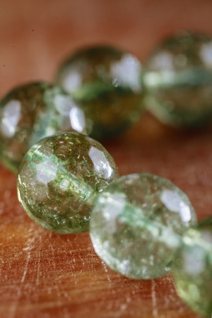 marble bead of green color on wooden backgroundの写真素材