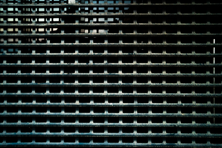 Metal mesh. Wall of metal grid. Metal structure of the bars and mesh. Dark worn rusty metal grid...