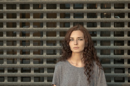 Depressed Girl In front Of metal Mesh. Teenager Prisoner Concept. A Lot Of Copyspace.