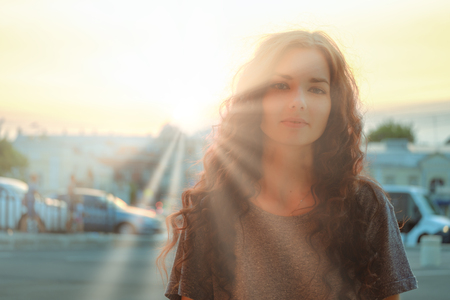 Soft Focus blurry portrait of cute woman in sunset sunrays backlit imageの写真素材