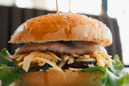 Closeup of chicken burger on table in cafeの写真素材