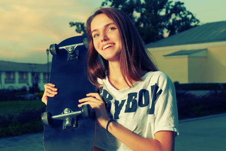 Happy redhair teen with skateboard vintage color toned imageの写真素材