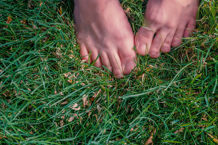Foot in the grass. Female bare foot top view a lot of space for text