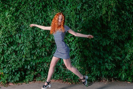 Having fun. Cute redhead girl having fun in front of grape wall, shot with copyspaceの写真素材