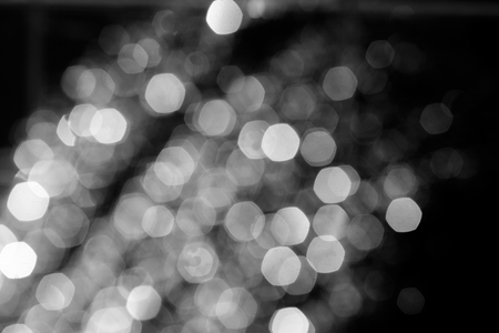 Blurry christmas lights on dark background, shining defocused snowflakes or raindropsの写真素材