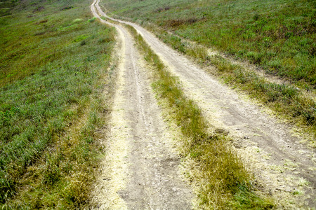 Road in arid landscape in green grassの写真素材