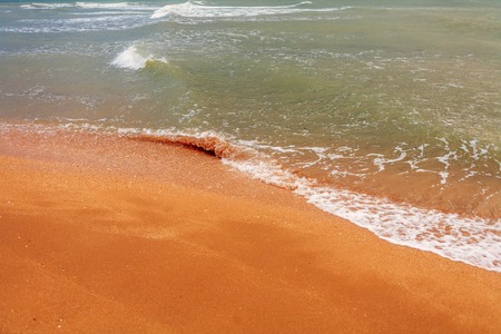 Calm sea and sandy coast with small wave coming on earthの写真素材
