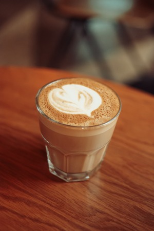 Flat-white coffe on tabletop from above view ith latte art on foamy topの写真素材