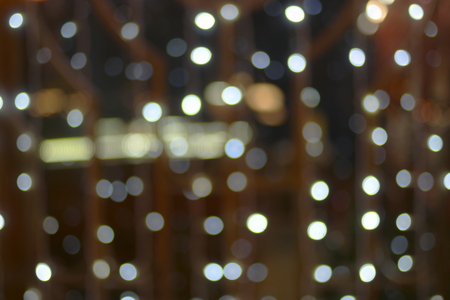 Blurred image of xmas garland cyan color on window in the nightの写真素材