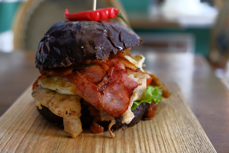 Big messy burger served on chopping board in pubの写真素材