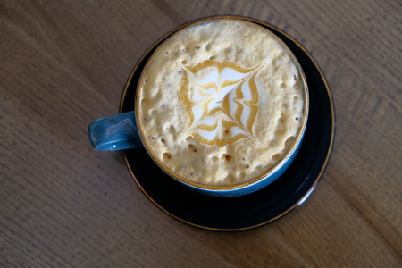 Coffee cup with perfect latte art on foam top view on tabletopの写真素材