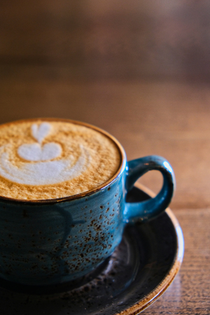 Half of the cappuccino cup on tabletop shot with copyspaceの写真素材