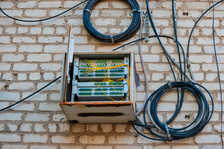 Fiber Optic Patch Panel On Apartment Building Wall With Coils Of Wires Nearの写真素材