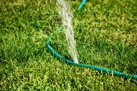 DIY lawn sprinkler working in grass spreading water all over the area about, copyspaceの写真素材