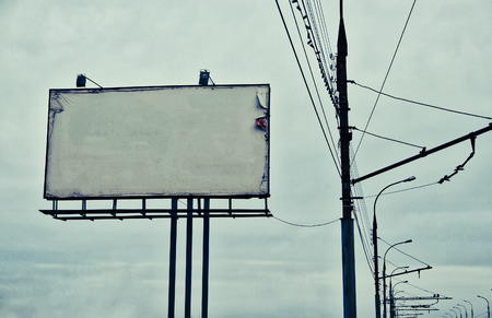 Roadside worn banner blank against dark cloudy skyの写真素材
