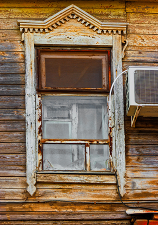 Shabby window of old wooden house with one-piece air cooling system installed front viewの写真素材