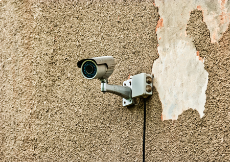 CCTV security camera mounted on the damaged wall outside the propertyの写真素材