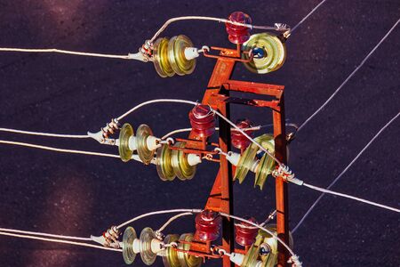 Closeup of electric insulators mounted on rusty power-towerの写真素材