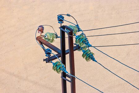 Closeup of electric insulators made of green glass mounted on rusty power-towerの写真素材
