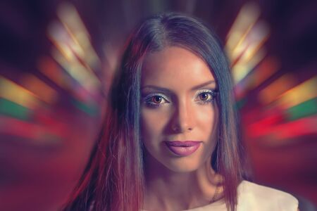 The shoulders and face of a very nice lady with evening makeup on her face in neon club light with...