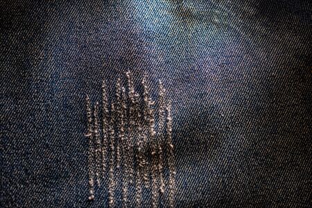 Scratched patch on the bleached denim fabric? background with copyspaceの写真素材