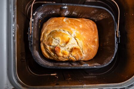 A freshly plepared loaf of homemade bread is inside bread-maker pan.の写真素材