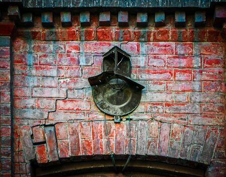 The wall of the old brick building is covered with cracks, it fortified the rusty number of the house, with the place of fixing the lampの写真素材