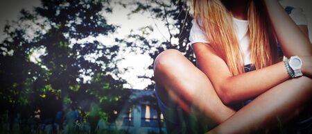 Girl in park resting cross legged on the grass, shot with copyspace, worm eye view