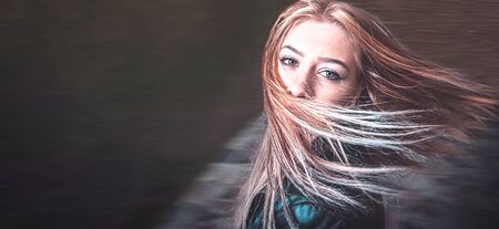 Long haired blonde is dancing in the park full of joy and happyness, a lot of copyspace on the right sideの写真素材