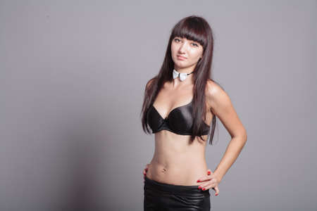 Nice woman in black bra and bow tie waist up shot.の写真素材