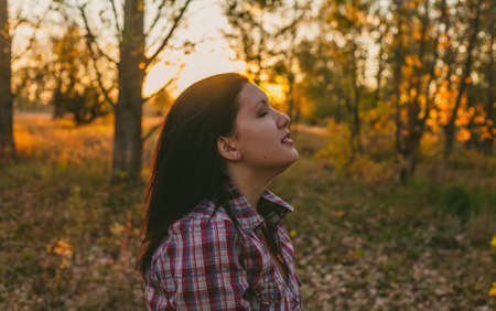 Exited girl in the woods at sunsetの写真素材