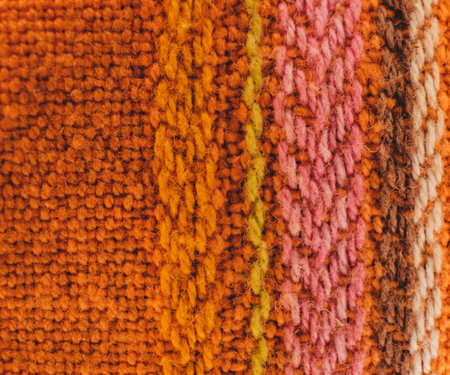 Macro of a rough fabric of orange and yellow and pink colours. Copyspace. Frame for text.