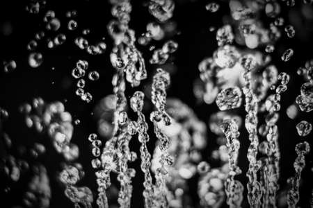 Drops of water levitate on dark background, waterdrops flying on blackの写真素材