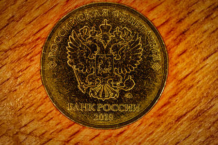 Modern russian coin of golden alloy. Revers with seal of Bank of Russia depicting twin headed eagle with heraldic signs. Words in russian - Russian Federation. Bank of Russia, 2018の写真素材