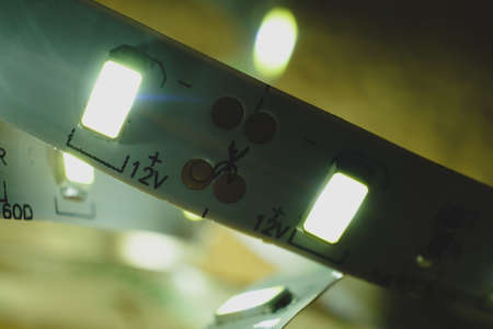 White led strip shining macro image. Modern light source 12V with marks for cutting.の写真素材