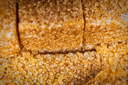 Row of organic brown sugar bricks macro, shallow DOF