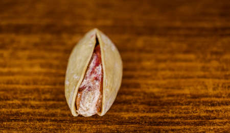Salted Pistachio in shell on a wooden cutting board macro image with copyspaceの写真素材