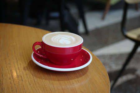 Red cup of coffee. Cappuccino, Cappucino in Coffee House served on tableの写真素材