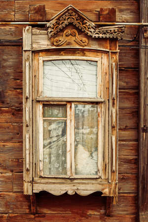Close up of wooden window in russian country house with half broken decorations.の写真素材