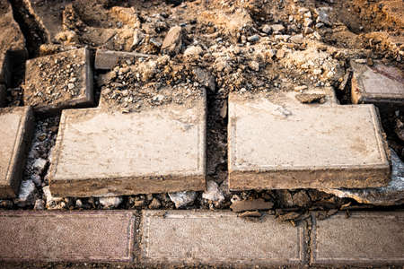 Footwalk repair. Broken pavements paving slabs on sidewalk near trench. Pavement with paving slabs with defects and cracks coming in closeup.の写真素材