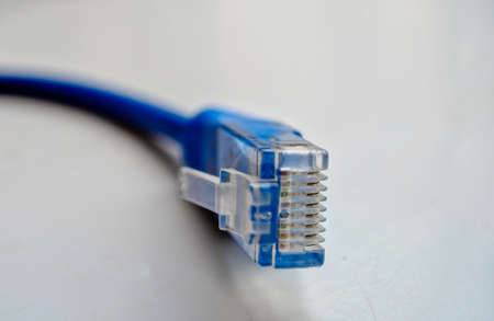 Macro cross section front angle view of blue RJ45 CAT6 shielded network data internet cable connector on gray background with copyspace.の写真素材