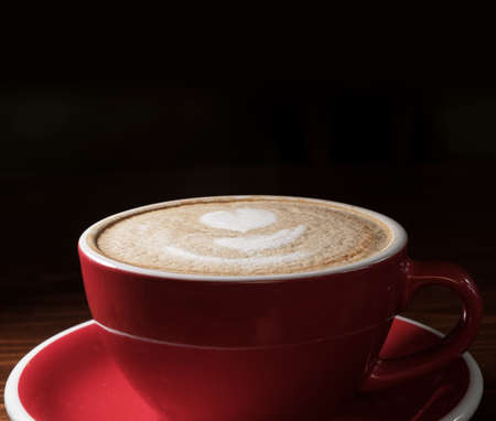 Coffee cup on dark background with copyspace. Latte art o9n top froth, above view.の写真素材