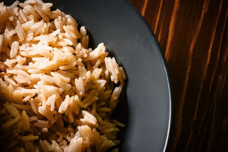 Above view of a rice bowl on a dark wooden table with space for designers copyspace.の写真素材