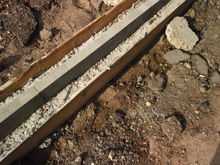 Road reconstruction. New curbstone installed and fixed with concrete, copyspace.の写真素材