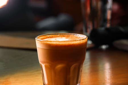 Coffee cup in transparent glass with froth on top, copyspaceの写真素材
