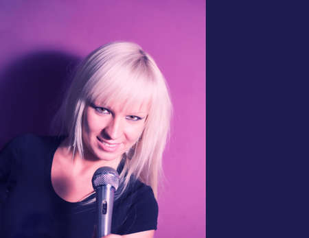 Lifestyle of young people concept: Blond model girl singer with a mic on pink background with copy space.の写真素材
