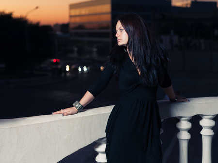 Women in little black dress posing outdoors near balustradeの写真素材