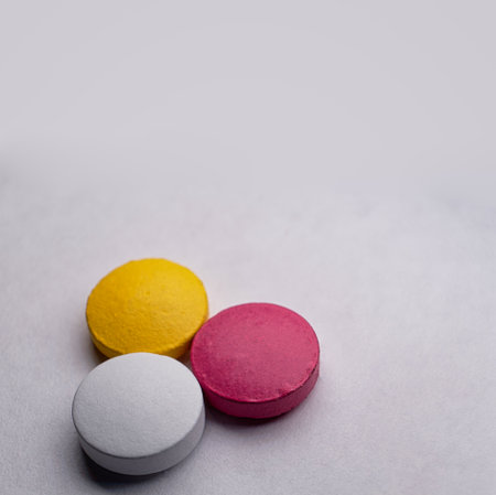 Macro of three medical pill tablet on white backdrop with copyspace atop.の写真素材