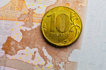 Golden 10 RUR russian ruble coin over euro banknote macro image - depicting EU economy crisis and recession by sanctions against Russia.の写真素材